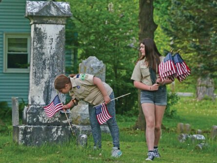 young people distribute flags in a cemetery