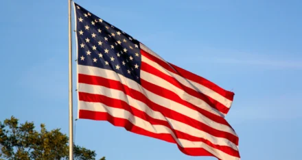 american flag flying on a pole.