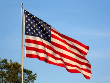 american flag flying on a pole.