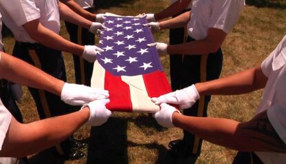 close shot of American flag in hands, they are folding the flag.