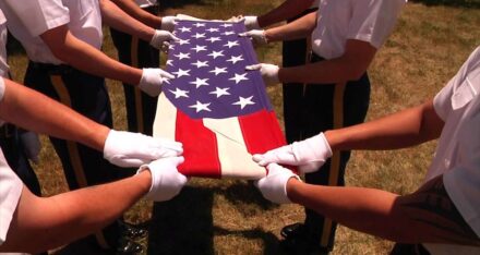 close shot of American flag in hands, they are folding the flag.