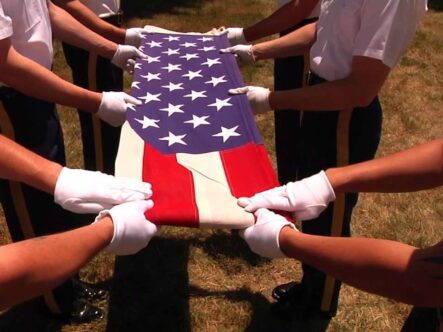 close shot of American flag in hands, they are folding the flag.